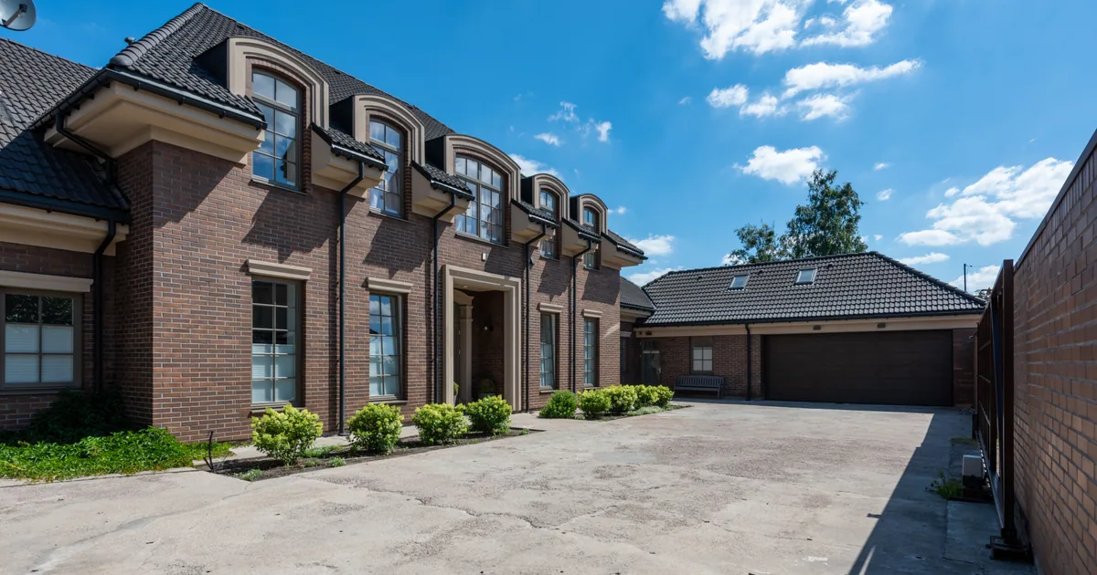 Brick house with a large driveway used to estimate pressure washing cost in Jacksonville FL